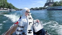 Lihatlah posenya saat berlayar mengelilingi Sungai Seine dengan latar Menara Eiffel.