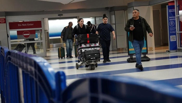 USA-TRAVEL/ A traveler waits for his vehicle at an Uber passenger pick-up area at Terminal 8 at John F. Kennedy International Airport, ahead of U.S. President Donald Trump?s reinstatement of a new travel ban barring citizens of 12 countries from entering the U.S., in New York, U.S., June 8, 2025. REUTERS/Bing Guan