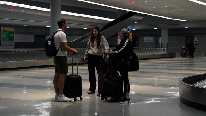 USA-TRAVEL/ A traveler waits for his vehicle at an Uber passenger pick-up area at Terminal 8 at John F. Kennedy International Airport, ahead of U.S. President Donald Trump?s reinstatement of a new travel ban barring citizens of 12 countries from entering the U.S., in New York, U.S., June 8, 2025. REUTERS/Bing Guan