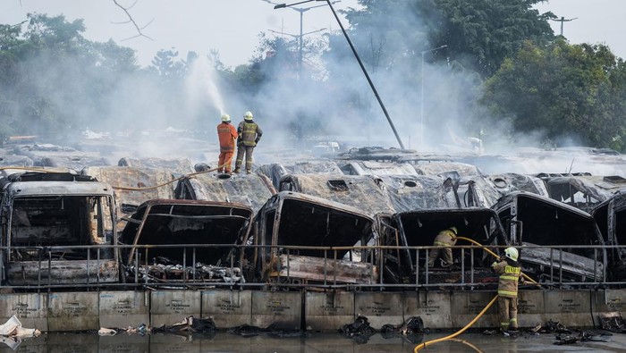 Petugas pemadam kebakaran melakukan proses pendinginan usai memadamkan api yang membakar bus Transjakarta bekas di Terminal Rawa Buaya, Jakarta, Selasa (10/6/2025). Kebakaran tersebut menghanguskan 50 bus Transjakarta bekas yang diduga akibat percikan api saat proses pengelasan yang mengenai bahan mudah terbakar. ANTARA FOTO/Putra M. Akbar/tom.