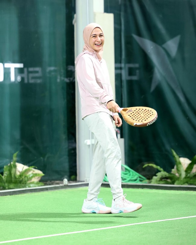 Perpaduan warna pink dan cream jadi andalan Nina Zatulini saat berolahraga padel. Dengan hijab olahraga pink dan jaket senada, penampilannya memancarkan kesan feminin, segar, dan tetap aktif di lapangan. Foto: Dok. Instagram @ninazatulini22.