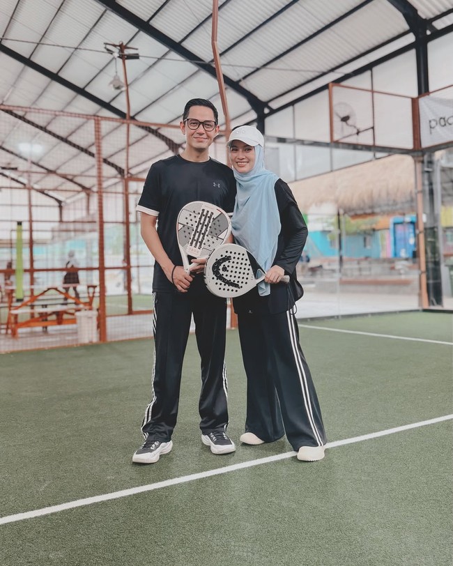 Alyssa Soebandono tampil anggun dan sporty dengan hijab syari warna biru yang dipadukan dengan topi cream serta setelan olahraga hitam saat bermain padel. Ia ditemani oleh suami, Dude Herlino saat bermain padel. Foto: Dok. Instagram @ichasoebandono.