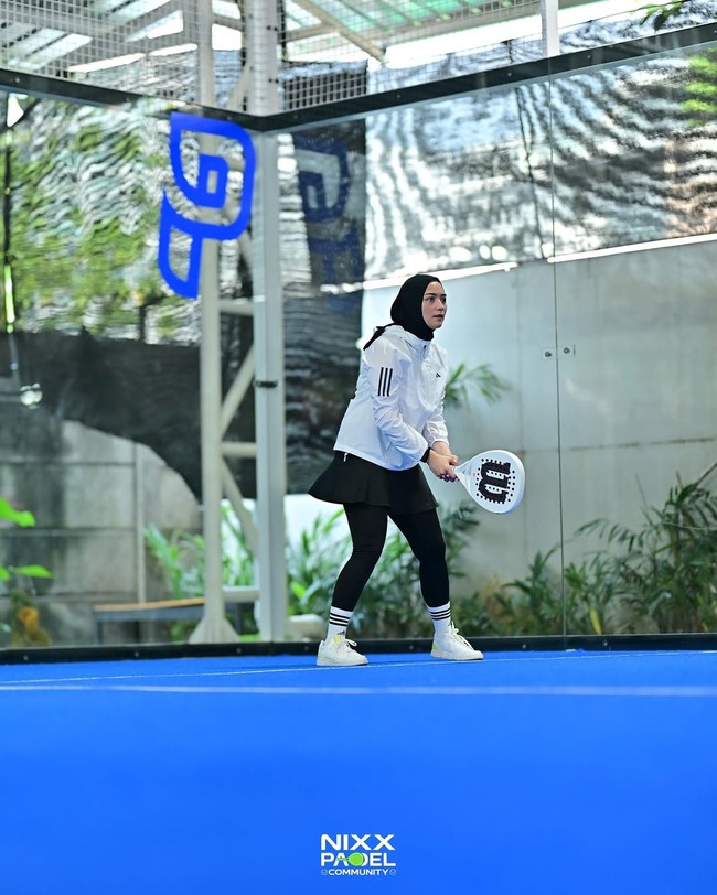 Citra Kirana tampil sporty dengan hijab olahraga hitam yang dipadukan dengan jaket dan sneaker putih saat bermain padel. Perpaduan warna monokrom yang simpel ini menjadi andalan para hijabers untuk olahraga. Foto: Dok. Instagram @citraciki.