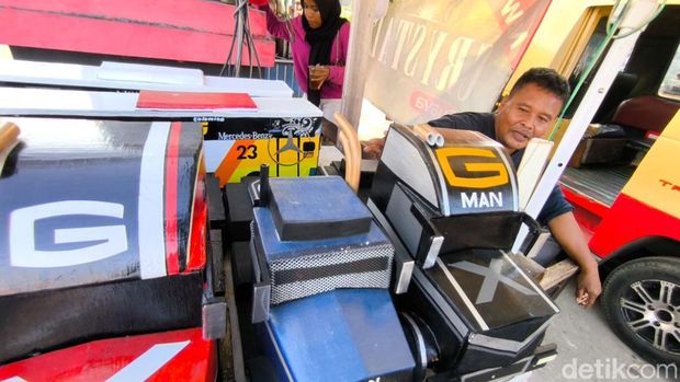 Jarwo saat sedang berjualan mobil miniatur kayu di Kuningan