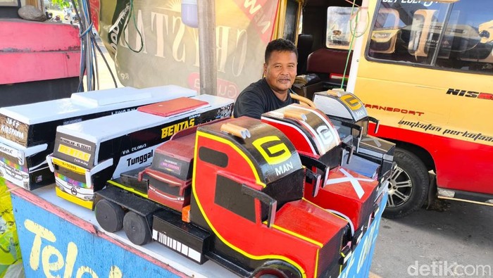 Jarwo saat sedang berjualan mobil miniatur kayu di Kuningan