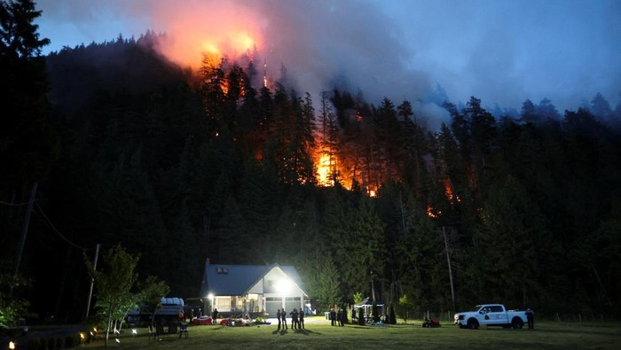 Api melalap hutan di Squamish, British Columbia, Kanada. Kebakaran mendekati permukiman warga, memaksa petugas berjibaku menahan api agar tak meluas.