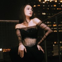 Dengan latar gedung-gedung kota di malam hari, penampilan Luna terasa seperti karakter femme fatale dari film noir masa kini—elegan dan memikat. Foto: Instagram/@hiantjen