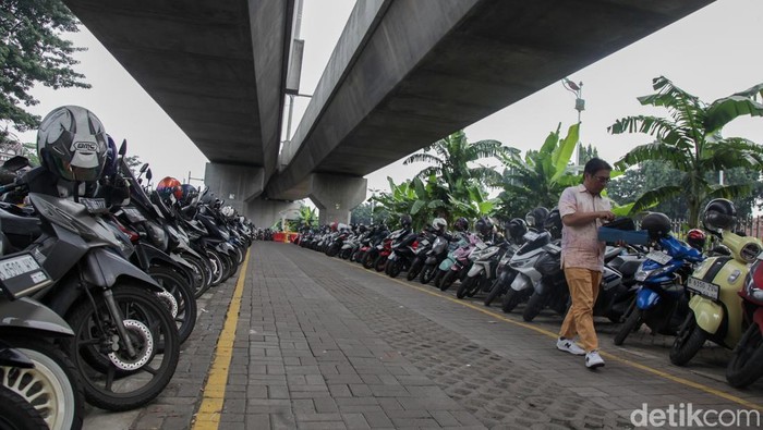 Parkir MRT Lebak Bulus Direvitalisasi, Tarif Nggak Flat Lagi Pengendara sepeda motor menempelkan kartu uang elektronik di gerbang Park and Ride MRT Lebak Bulus, Jakarta, Selasa (10/6/2025). Parkir sepeda motor tidak lagi dikenakan tarif flat Rp 2 ribu.