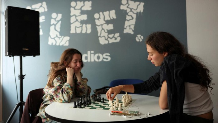 Emily Raad, 28, from east London, reacts while playing chess at Knight Club, a diverse chess club growing to almost a thousand members within a year, based at Fleet Studios, in London, Britain, June 3, 2025. REUTERS/Isabel Infantes