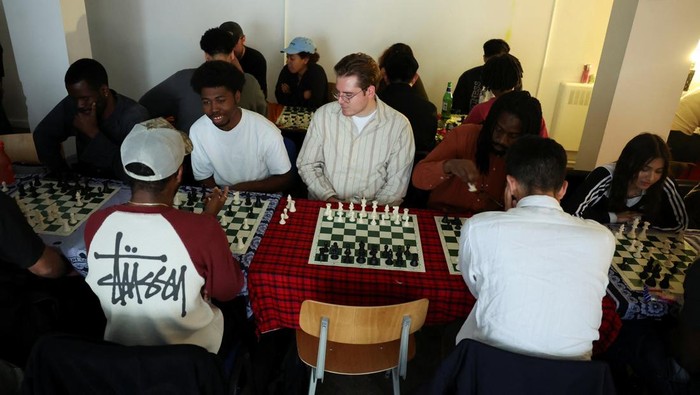 Emily Raad, 28, from east London, reacts while playing chess at Knight Club, a diverse chess club growing to almost a thousand members within a year, based at Fleet Studios, in London, Britain, June 3, 2025. REUTERS/Isabel Infantes