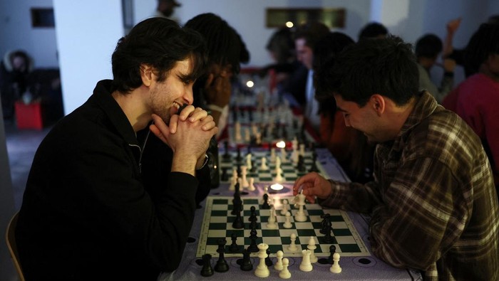 Emily Raad, 28, from east London, reacts while playing chess at Knight Club, a diverse chess club growing to almost a thousand members within a year, based at Fleet Studios, in London, Britain, June 3, 2025. REUTERS/Isabel Infantes