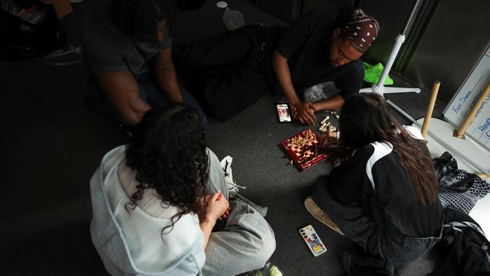 Emily Raad, 28, from east London, reacts while playing chess at Knight Club, a diverse chess club growing to almost a thousand members within a year, based at Fleet Studios, in London, Britain, June 3, 2025. REUTERS/Isabel Infantes