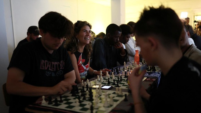 Emily Raad, 28, from east London, reacts while playing chess at Knight Club, a diverse chess club growing to almost a thousand members within a year, based at Fleet Studios, in London, Britain, June 3, 2025. REUTERS/Isabel Infantes