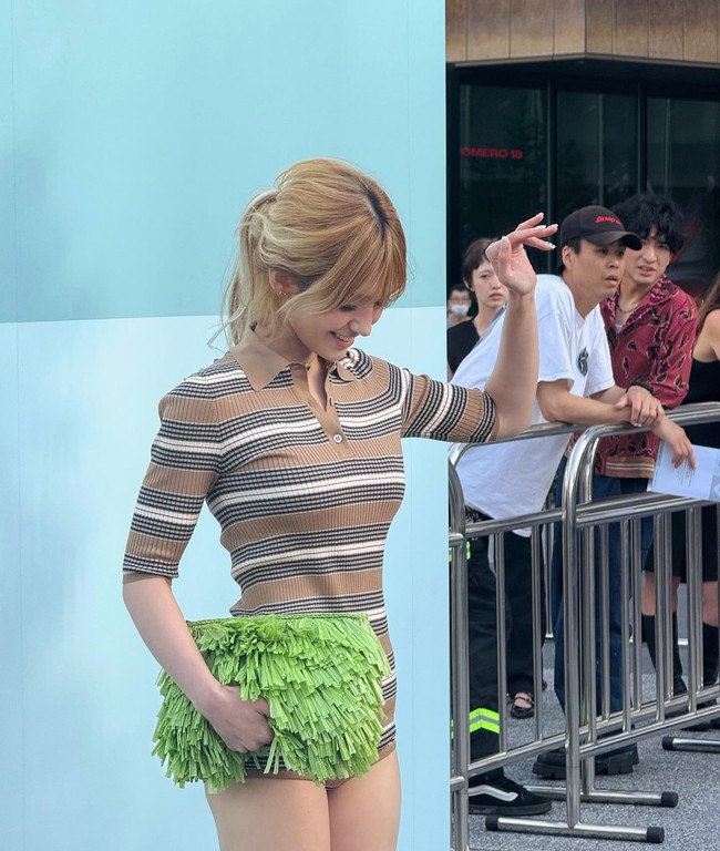 Penampilannya semakin mencuri atensi dengan clutch hijau neo berumbai ini. Foto: Instagram @somsomi0309