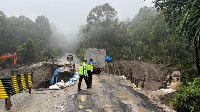 Teks foto: Petugas Satlantas saat mengatur lalu lintas di lokasi jalan amblas. (Dok. Polres Dairi)