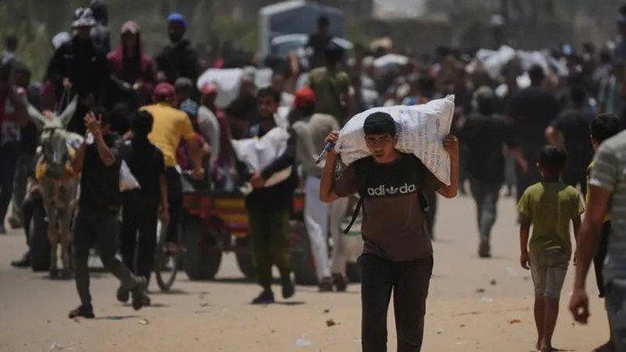 Palestinians carry bags containing food and humanitarian aid packages delivered by the Gaza Humanitarian Foundation, a U.S.-backed organization, in Rafah, southern Gaza Strip, Monday, June 9, 2025. (AP)