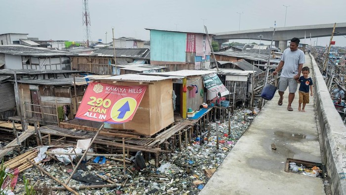 Warga berjalan di dekat permukiman kumuh di Kosambi, Kabupaten Tangerang, Banten, Selasa (10/6/2025). Badan Pusat Statistik (BPS) mencatat dalam rentang waktu sepuluh tahun terakhir jumlah penduduk miskin di Indonesia turun sekitar 3,06 juta orang menjadi 25,22 juta orang pada Maret 2024 atau menurun 2,22 persen dibandingkan Maret 2014 yang berjumlah 28,28 juta orang. ANTARA FOTO/Putra M. Akbar