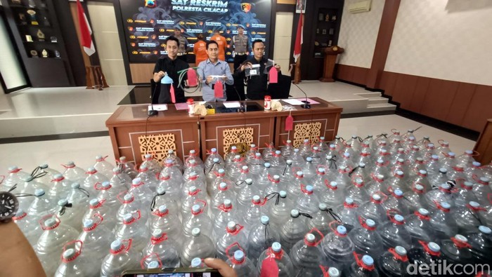 Polisi menunjukkan barang bukti puluhan galon untuk tampung BBM Pertalite yang dijual ilegal oleh sejoli saat ungkap kasus di Mapolresta Cilacap, Rabu (11/6/2025).