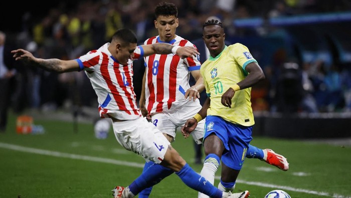 Soccer Football - World Cup - South American Qualifiers - Brazil v Paraguay - Neo Quimica Arena, Sao Paulo, Brazil - June 10, 2025 Brazils Vinicius Junior in action with Paraguays Juan Caceres and Diego Gomez REUTERS/Jorge Silva