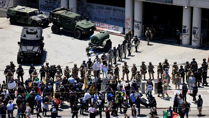 Members of security services stand next to demonstrators outside the Edward R. Roybal Federal building during a protest against federal immigration sweeps in downtown Los Angeles, California, U.S. June 10, 2025. REUTERS/David Swanson
