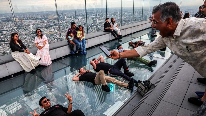 Tourists pose as they enjoy the Mahanakhon Skywalk Rooftop at Mahanakhon building in Bangkok, Thailand, May 15, 2025. REUTERS/Athit Perawongmetha     TPX IMAGES OF THE DAY