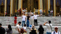 Detail ukiran emas dan mosaik warna-warni memperindah gerbang masuk Grand Palace, menjadi latar favorit untuk berswafoto para turis. Foto: REUTERS/Athit Perawongmetha