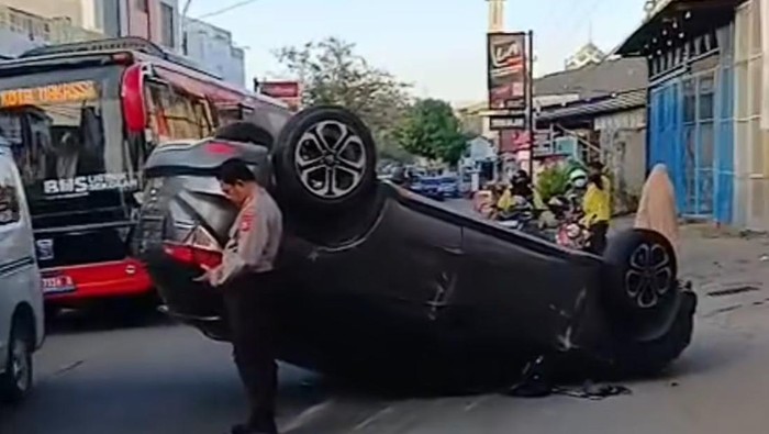 Mobil terbalik usai terlibat tabrakan di Jalan Batu Raya Makassar.