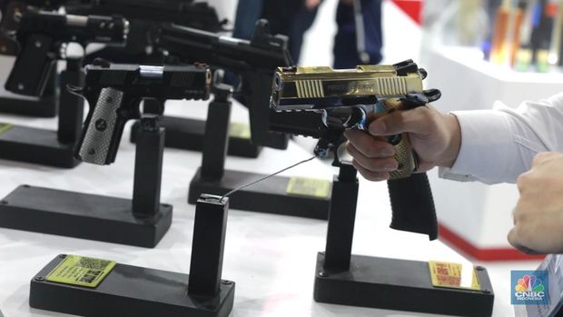 Pengunjung memegang pistol buatan Pindad di pameran industri pertahanan internasional Indo Defence Expo & Forum 2025 di JIEXPO Kemayoran, Jakarta Pusat, Rabu (11/6/2025). (CNBC Indonesia/Muhammad Sabki)