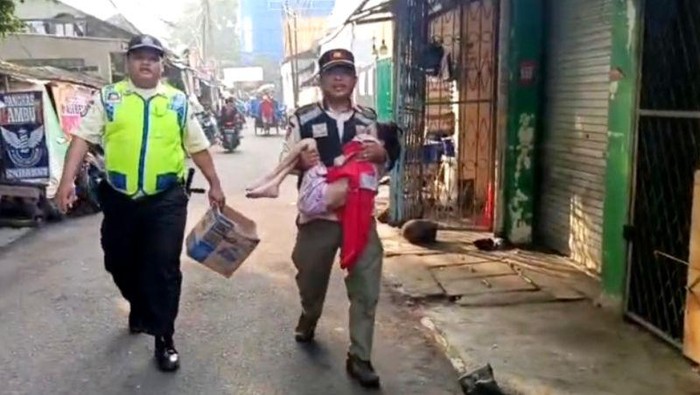 Satpol PP Kebayoran Lama mengamankan seorang anak yang diduga disiksa oleh orang tuanya di Pasar Kebayoran Lama, Jakarta Selatan, Rabu (11/6/2025).