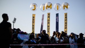 Ada yang bawa serangkaian balon bertuliskan nama member lo. Istimewa banget! (Foto: AFP/ANTHONY WALLACE)