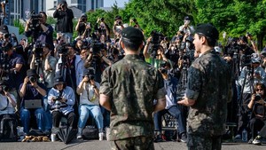 ARMY menyambut kembalinya Jungkook dan Jimin dengan meriah. (Foto: AFP/ANTHONY WALLACE)