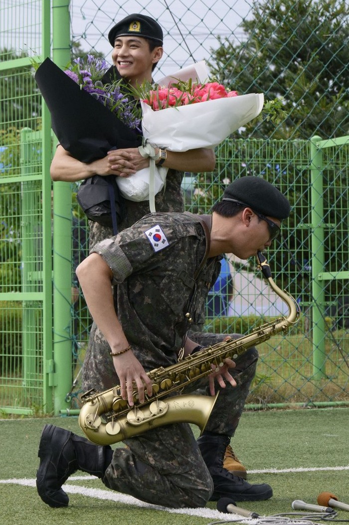 K-pop boy band BTS members RM (L) and V salute at an outdoor sporting facility in Chuncheon on June 10, 2025, after their release from 18 months of South Korean military service. Hundreds of fans gathered near two army bases just outside of the capital Seoul where band leader RM -- recently named 