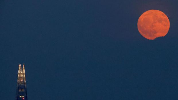 People watch the full moon known as the Strawberry Moon rise, as seen from Hampstead Heath, in London, Britain, June 10, 2025.  REUTERS/Peter Cziborra