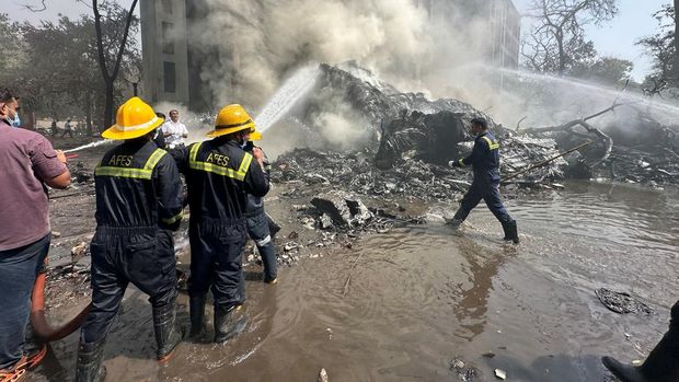 Anggota tim penyelamat bekerja saat asap mengepul di lokasi jatuhnya pesawat Air India di Ahmedabad, India, 12 Juni 2025. (REUTERS/Amit Dave)
