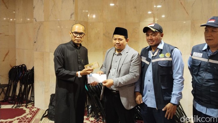 BPKH Limited menyerahkan kompensasi ke jemaah haji yang terdampak kendala pengiriman konsumsi. Kompensasi itu berupa uang tunai. (Haris/detikcom)