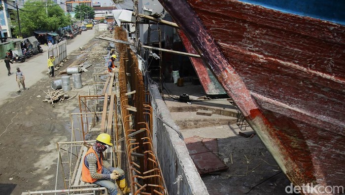 Pekerja kebut pembangunan tanggul rob di Docking Kapal Pluit. Tanggul setinggi 3,6 meter ini ditargetkan selesai Agustus 2025.