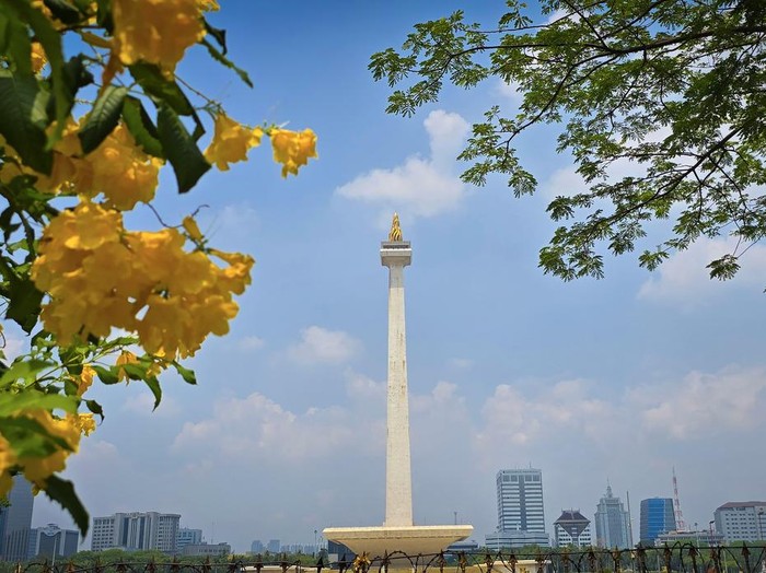 Jakarta city, Indonesia, 25 October 2024, Scenic view of the National Monument or Monas around city skyscrapers under a clear blue sky and sunny day, good for news article or multimedia content creation
