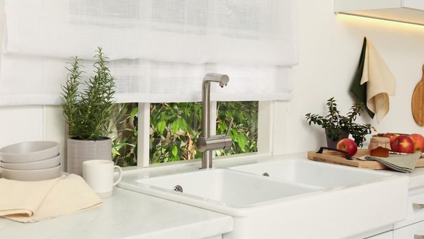White sink with tap near window in kitchen. Interior design