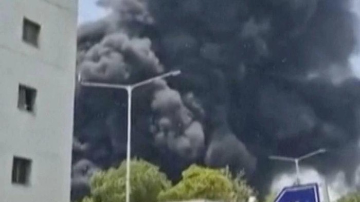 Kepulan asap menjulang ke udara dari lokasi jatuhnya pesawat Air India di dekat bandara di Ahmedabad (Mohan Nakum via AP)