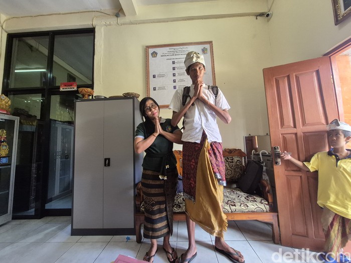 Komang Tri Mahendra alias Komang Wahyu berpose bersama gurunya di SLBN 1 Gianyar, Kamis (12/6/2025). (Foto: Ni Komang Ayu Leona Wirawan/detikBali)