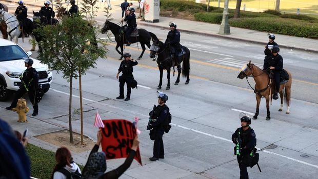 Police officers stand guard during a protest against federal immigration sweeps, in Los Angeles, California, U.S., June 11, 2025. REUTERS/David Swanson