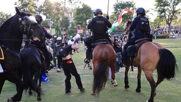 Law enforcement officers ride on horses as they disperse crowd during a protest against federal immigration sweeps, in Los Angeles, California, U.S., June 11, 2025. REUTERS/David Swanson