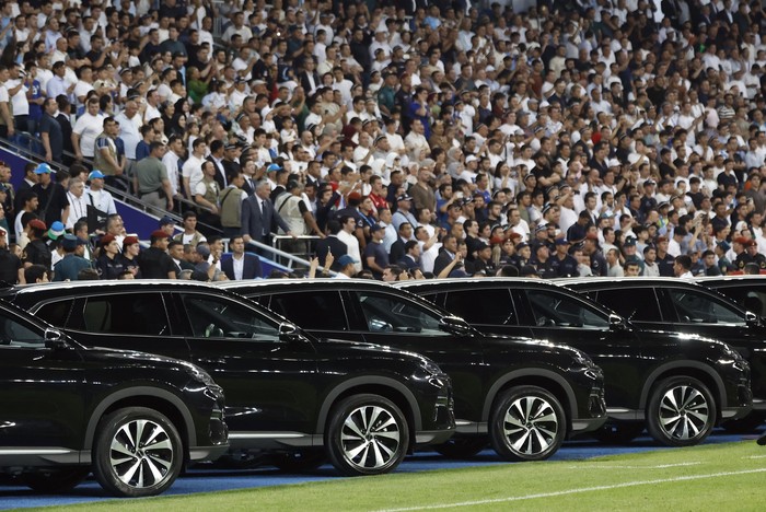 Uzbekistan President Shavkat Mirziyoyev is driven onto the pitch to honor the national football team after securing a spot at the 2026 FIFA World Cup