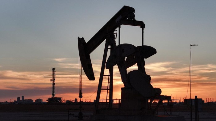 A drone view of a pump jack and drilling rig south of Midland, Texas, U.S. June 11, 2025. REUTERS/Eli Hartman