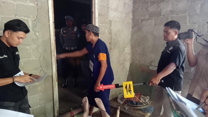 Pelaku Bobi (34) saat melakukan adegan rekonstruksi pembunuhan dan mutilasi yang dilakukannya. (Foto: Istimewa)