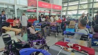 Penumpang memadati loket tiket Air India di Bandara Delhi setelah penerbangan tertunda dan dibatalkan imbas konflik udara antara Israel dan Iran, Jumat (13/6/2025). REUTERS/Bhawika Chhabra