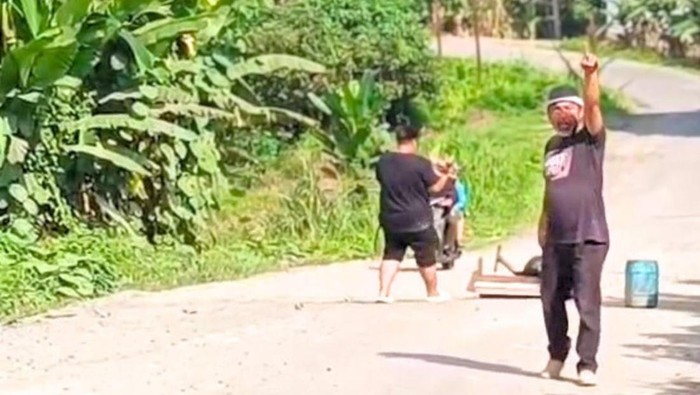 Radang Lukas saat menggelar aksi bakar ban di area Patung Buaya, Desa Pulau Sapi, pada Selasa (10/6/2025).