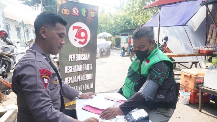 Satuan Brimob Polda Metro Jaya memberikan pelayanan kesehatan kepada ojol di pangkalan ojek.