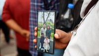 Di tengah hiruk-pikuk suasana, Ayyub Sheikh (49) menunjukkan foto keponakan dan keluarganya yang turut menjadi korban. REUTERS/Amit Dave