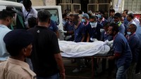 Petugas rumah sakit dengan hati-hati memuat jenazah ke dalam kendaraan yang telah disiapkan. REUTERS/Amit Dave